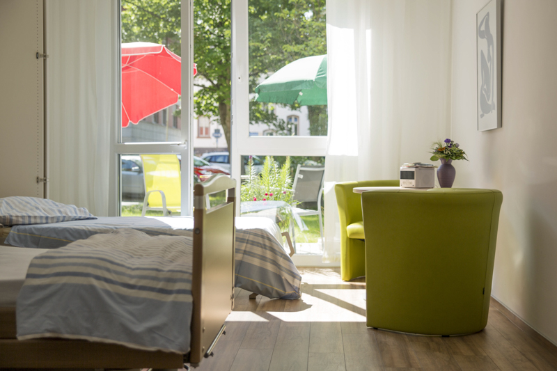 Patientenzimmer mit zusätzlichem Schrankbett für Angehörige.